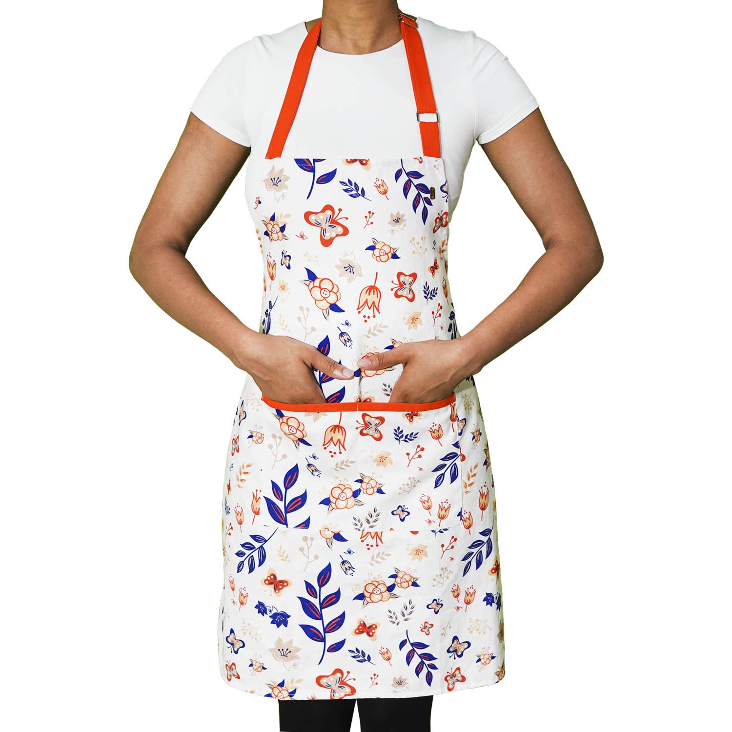 Model wearing the floral apron with orange neck and pocket trim